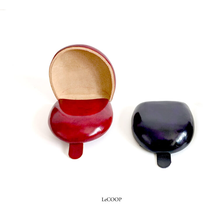 Monedero de cuero rojo abierto y monedero morado cerrado, de cuero moldeado