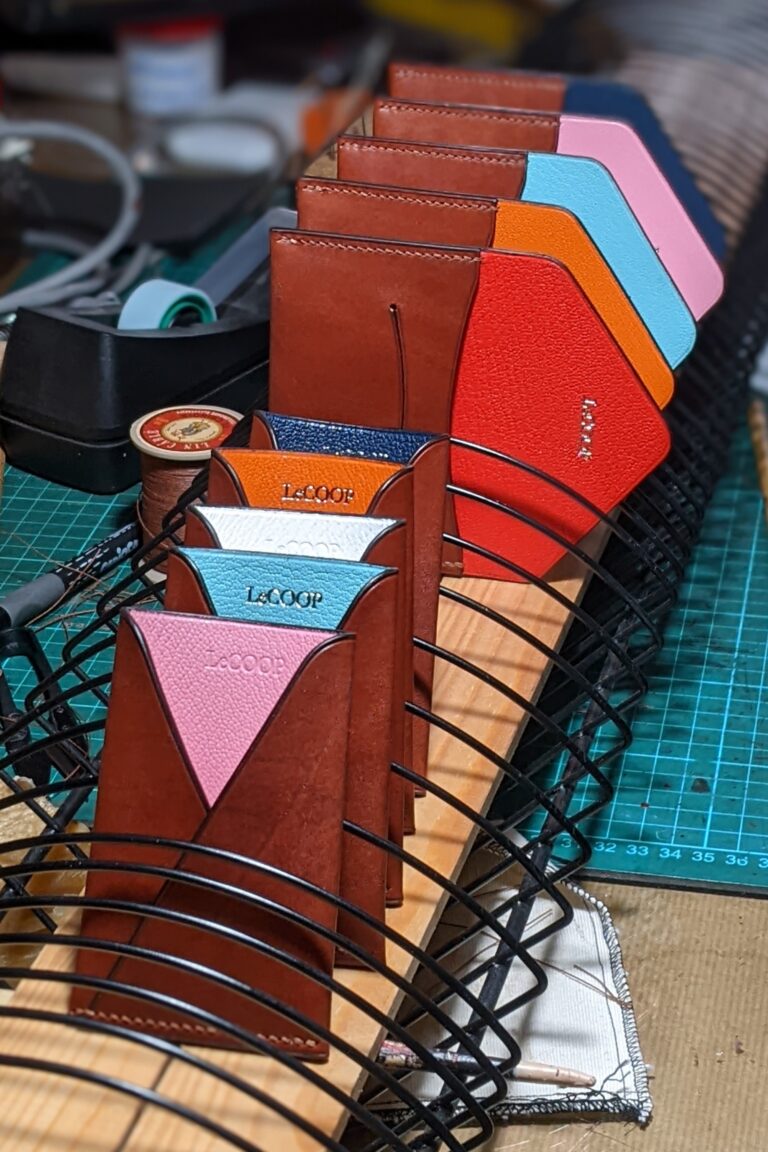 Tarjeteros de cuero marrón con interior rojo, azul, rosa y naranja y la marca LeCOOP grabada