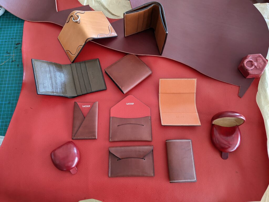 Carteras, tarjeteros y monederos de cuero colocados sobre una piel roja